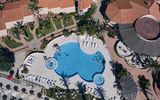 Großzügiger Poolbereich mit Whirlpool und Liegeflächen – perfekt für erholsame Stunden unter Palmen.