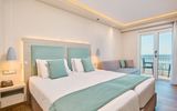 Helles, modern eingerichtetes Doppelzimmer mit eleganter Farbkombination aus Weiß und Mint sowie direktem Zugang zum Balkon mit traumhaftem Meerblick.