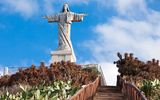 Die Christo-Rei-Statue auf Madeira: Eine eindrucksvolle Christusstatue mit ausgebreiteten Armen, stehend auf einem Felsvorsprung mit Blick auf den Atlantischen Ozean.