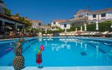 Erfrischender Pool, einladende Sonnenliegen und tropische Cocktails – perfekte Kulisse für entspannte Stunden in mediterraner Atmosphäre.