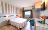 Modern eingerichtetes Zimmer mit gemütlichem Doppelbett, dezenten Farbakzenten und direktem Zugang zum Balkon mit Meerblick – ideal für entspannte Urlaubsmomente.