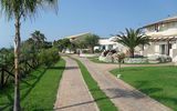 Weitläufige, gepflegte Gartenanlage mit mediterranem Flair und kleinen Wegen, die durch das Resort führen.