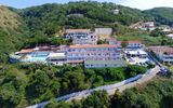 Weitläufige Hotelanlage in Hanglage, umgeben von grüner Natur – mit Panoramapool und großzügiger Sonnenterrasse.