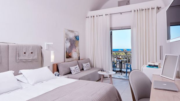 Helles, modern eingerichtetes Zimmer mit gemütlichem Bett, Sitzecke und Balkon – mit traumhaftem Blick auf das Meer und Palmen.