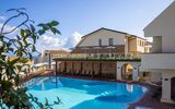 Moderner Hotelpool mit großzügiger Sonnenterrasse, gemütlichen Liegen und mediterranem Flair in zentraler Lage.