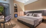 Modernes Doppelzimmer mit stilvollem Interieur, gemütlichem Bett, Schreibtisch und Minibar – ideal für entspannte Urlaubstage in elegantem Ambiente.