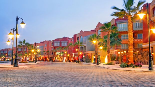 Hafenpromenade Hurghada mit Palmen vor den Gebäuden und leuchtenden Laternen