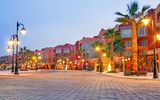 Hafenpromenade Hurghada mit Palmen vor den Gebäuden und leuchtenden Laternen